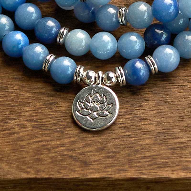 108 Mala Blue Aventurine Lotus Calm Bracelet – blue ombre bracelet with silver lotus charm on wood grain close-up, Calm