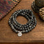 108 Mala Black Glitter Stone Lotus Bracelet - triple-strand black stone coils on wood, tribal textile, grounding
