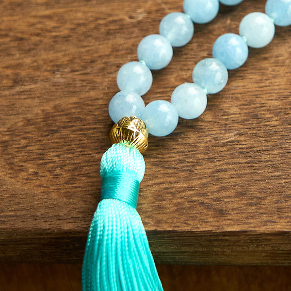 108 Mala Aquamarine Lotus Healing Bracelet – coiled loops of sky blue beads with lotus charm on minimalist wood, Peace