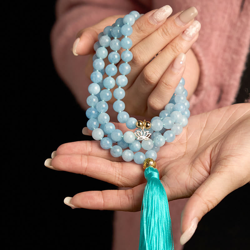108 Mala Aquamarine Lotus Healing Bracelet – 108 aquamarine beads with gold lotus charm and teal tassel in hands, Healing