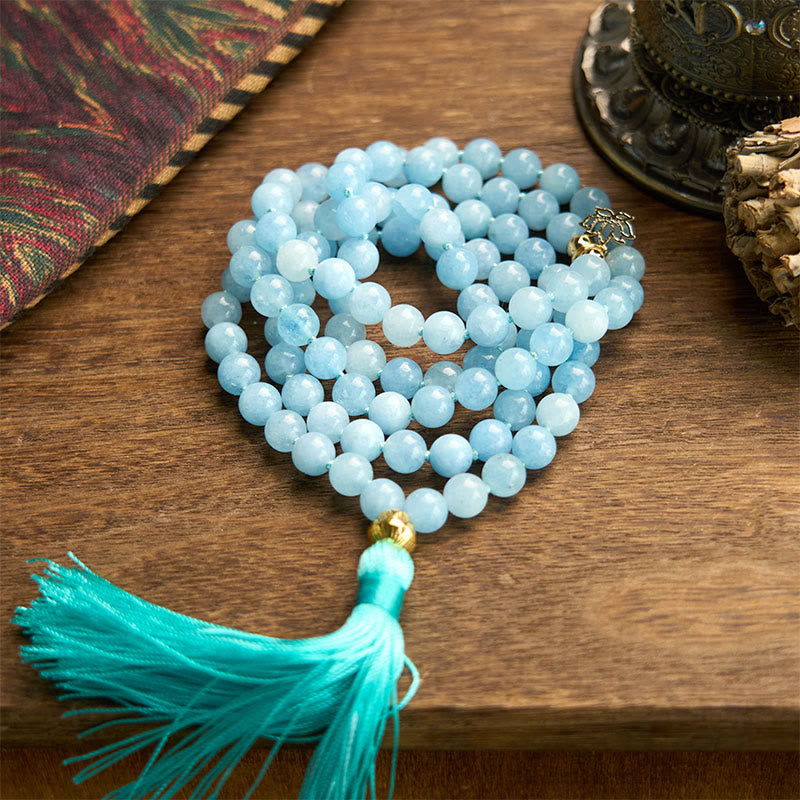 108 Mala Aquamarine Lotus Healing Bracelet – coiled aquamarine beads with turquoise silk tassel on wood, Peace