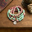 Mala Rhodonite Amazonite Lotus Bracelet - coiled on wood with fabric, mindful serenity