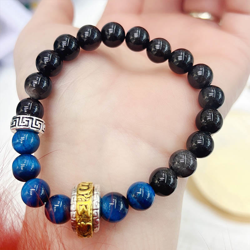 Om Mani Padme Hum Bracelet – Resting in open palm displaying blue and black stone beads, mindfulness jewelry