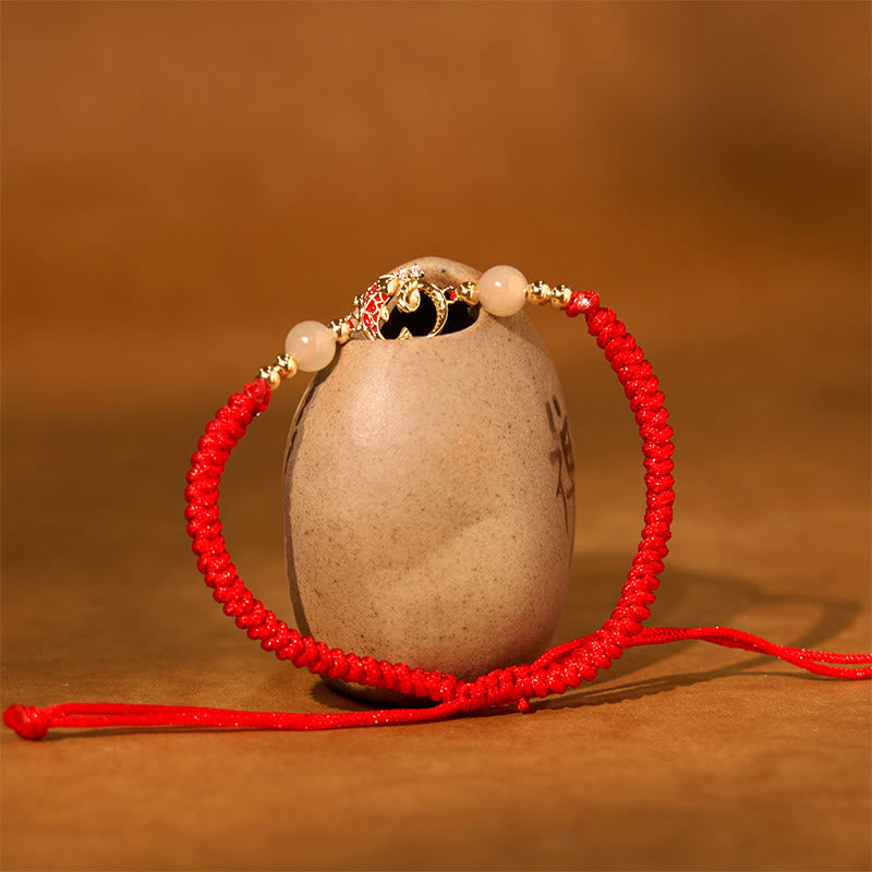 Silver Jade Cinnabar Koi Snake Bracelet – gold floral charm with jade beads on ceramic vessel, warm brown backdrop