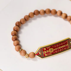 Sandalwood Bead Bagua Yin Yang Bracelet - angled view highlighting bagua symbols on red enamel pendant, wooden wrist mala