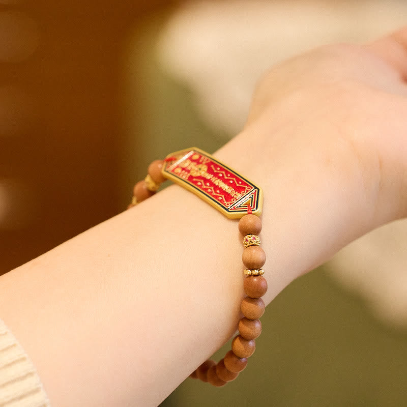 Sandalwood Bead Bagua Yin Yang Bracelet - close-up wrist shot showing red enamel charm and wood grain texture, zen bracelet