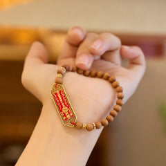 Sandalwood Bead Bagua Yin Yang Bracelet - worn on wrist showing sandalwood beads and red gold charm, harmony jewelry