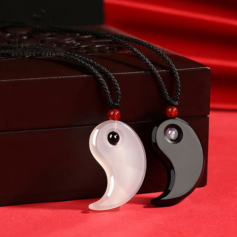 Black Onyx White Agate Yin Yang Necklace - Couple pendant set displayed with carved wooden gift box on red fabric, spiritu...