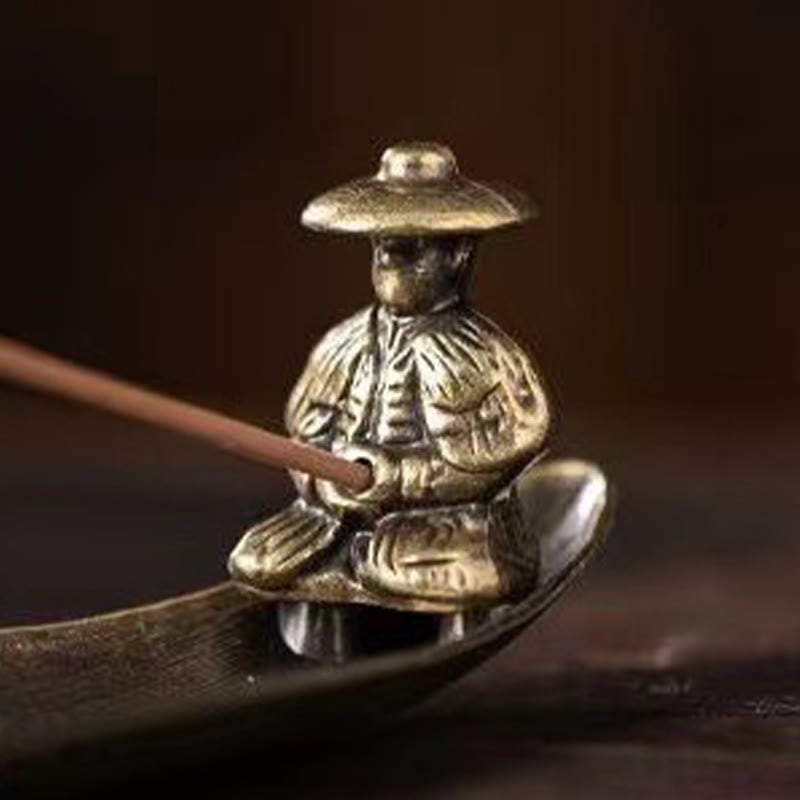 Koi Fish Boat Incense Burner - fisherman figure in boat holding incense, dark background, low angle view