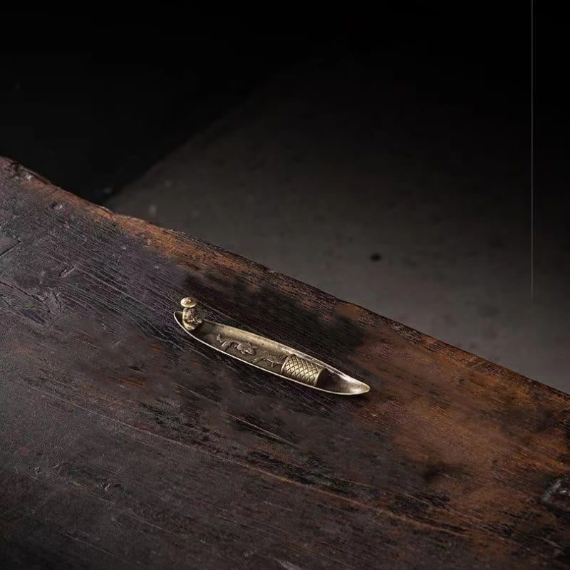 Koi Fish Boat Incense Burner - close-up of bronze boat with smoke, dark rustic wood, moody atmosphere