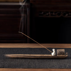 Fisherman Zen Ceramic Incense Burner – Boat-shaped brown holder with seated figurine and rising smoke, zen decor