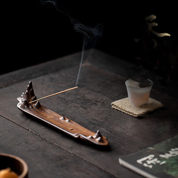 Mountains Boat Ceramic Incense Burner – brown mountain burner with incense smoke on tea table with book and cup, zen atmosphere