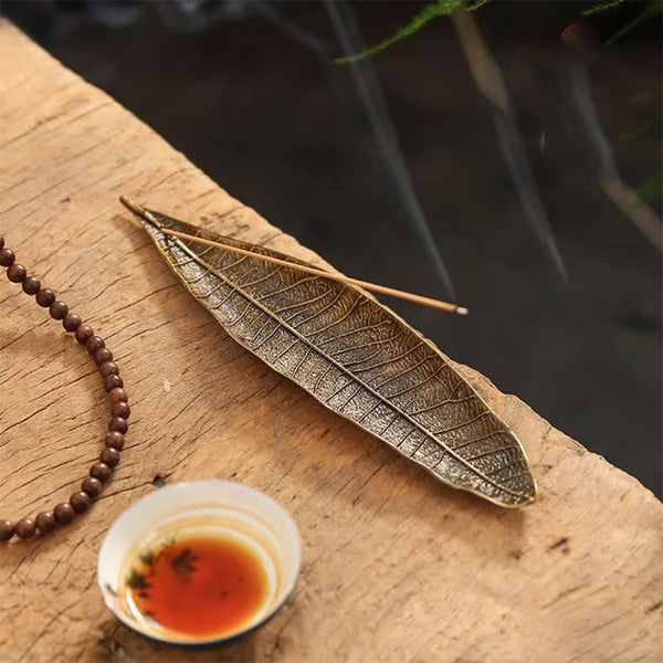 Oriental Leaf Alloy Incense Burner – reddish brown leaf holder with two incense sticks on wooden slab, tea meditation