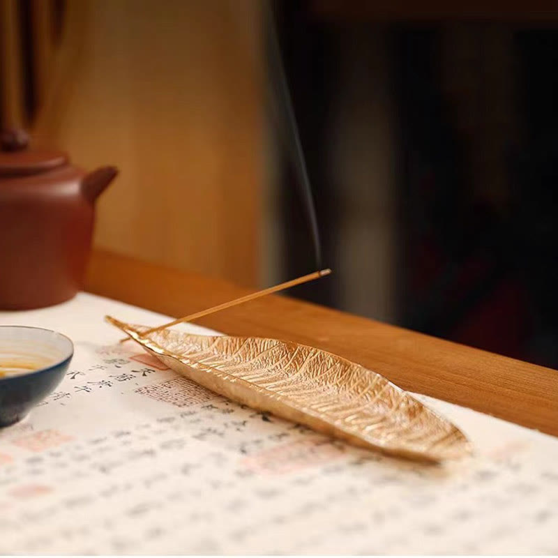 Oriental Leaf Alloy Incense Burner – gold leaf holder on tea table beside clay teapot and cup, serene tea ceremony