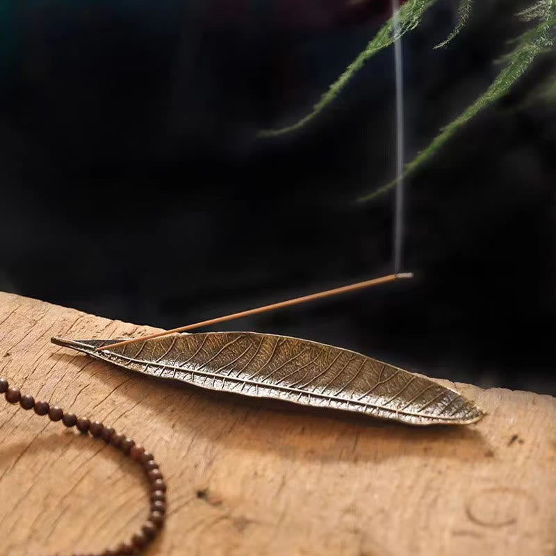 Oriental Leaf Alloy Incense Burner – reddish brown leaf holder with incense stick smoking on wood, nature inspired zen