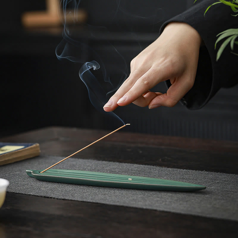 Green Bamboo Leaf Ceramic Incense Burner – finger touching incense smoke above dark green leaf holder, mindful moment