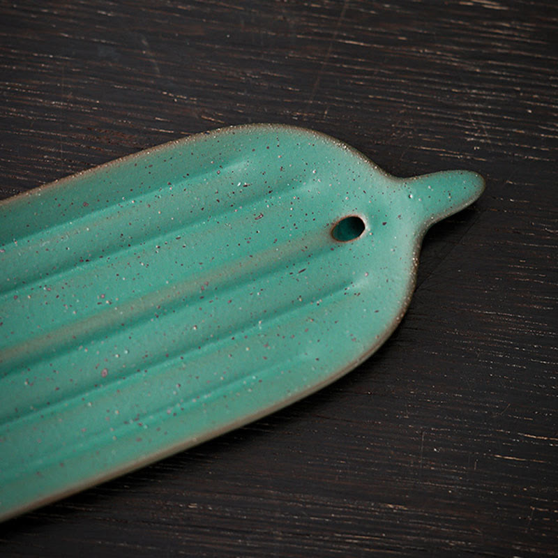 Green Bamboo Leaf Ceramic Incense Burner – close-up of light green glaze texture and incense hole on dark wood surface