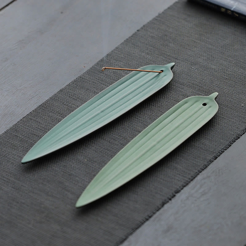 Green Bamboo Leaf Ceramic Incense Burner – two light green leaf holders side by side on grey tea mat, one with incense stick