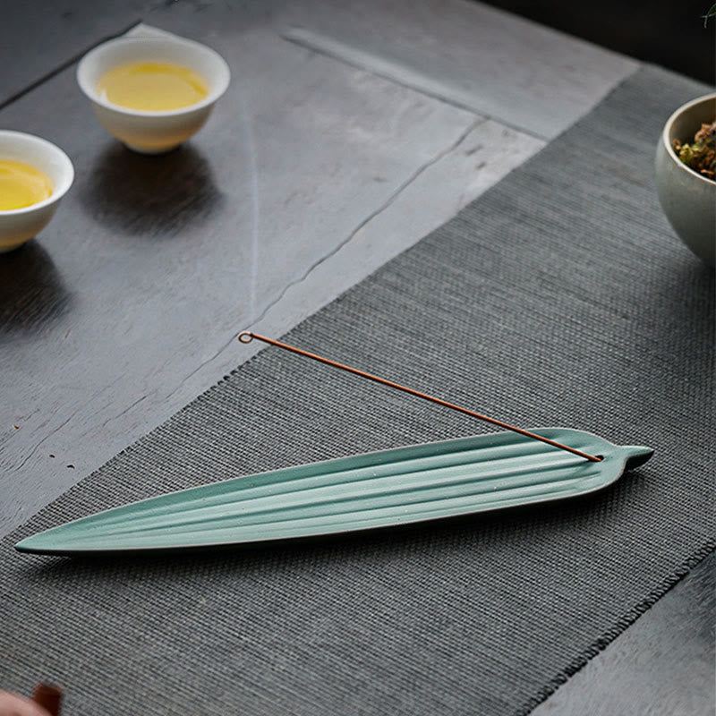 Green Bamboo Leaf Ceramic Incense Burner – light green leaf burner on grey tea mat with tea cups, peaceful tea setting