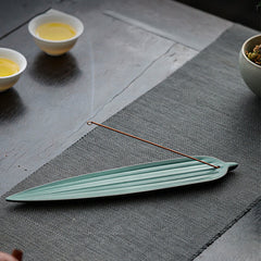 Green Bamboo Leaf Ceramic Incense Burner – light green leaf burner on grey tea mat with tea cups, peaceful tea setting