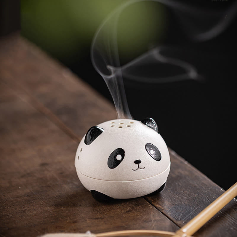 Cute Panda Ceramic Incense Burner – Angled view on wood table with smoke trails, blurred greenery behind