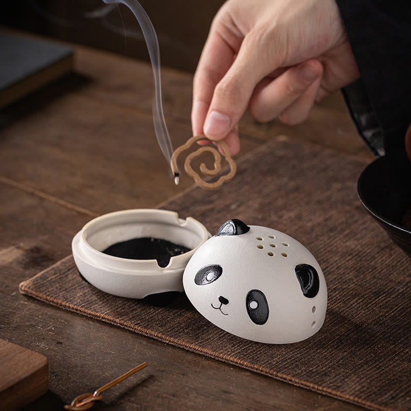 Cute Panda Ceramic Incense Burner – Hand placing coil incense into open panda base, brown mat scene