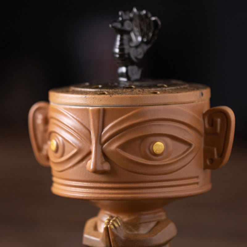 Sanxingdui Ceramic Incense Burner – close up of mask face with golden eyes and detailed relief, ancient art inspired