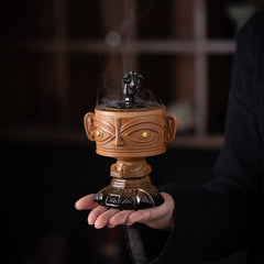 Sanxingdui Ceramic Incense Burner – palm holding yellow mask incense burner with smoke rising, spiritual ritual decor