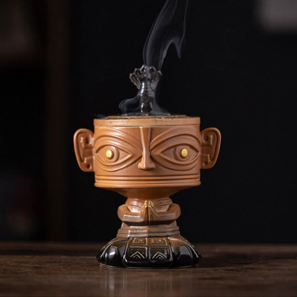 Sanxingdui Ceramic Incense Burner – front view of yellow mask burner with golden eyes and phoenix finial, meditation decor