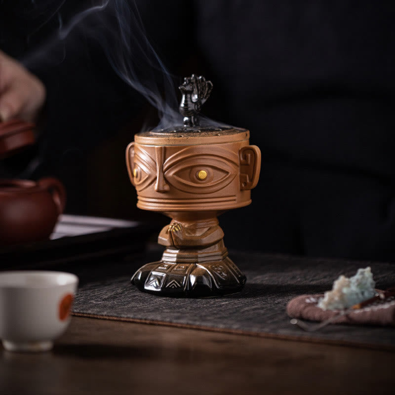 Sanxingdui Ceramic Incense Burner – yellow mask burner on tea mat with teacup and crystal stone, calming atmosphere