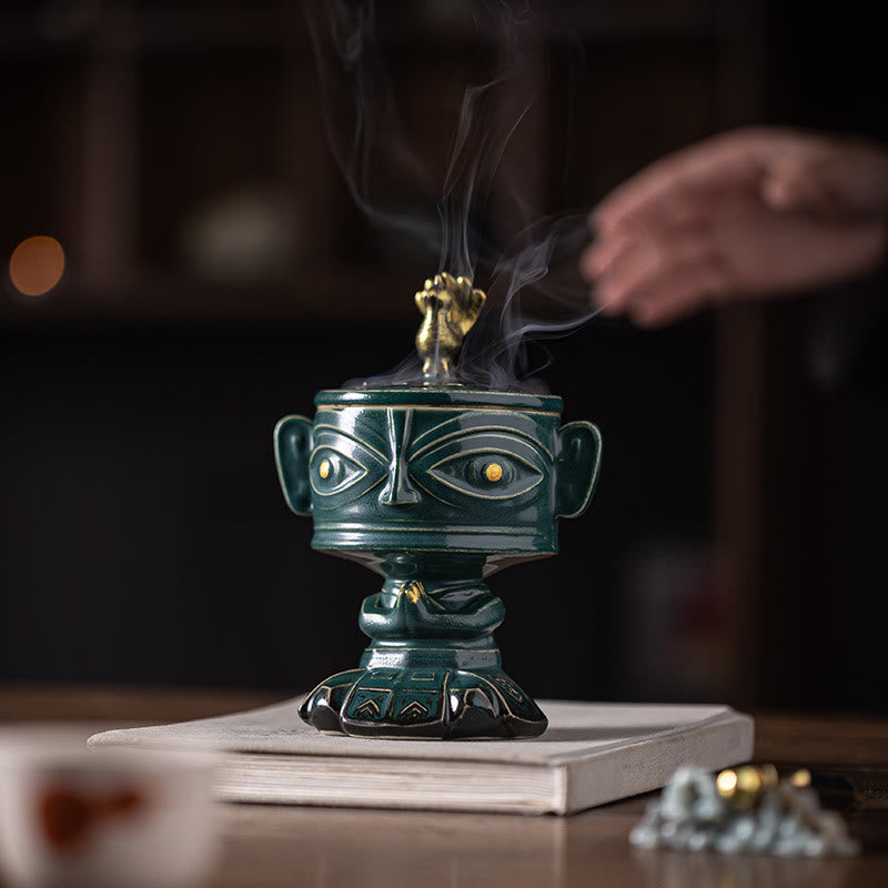 Sanxingdui Ceramic Incense Burner – green mask burner on wooden table with book and teaware, tranquil ambiance