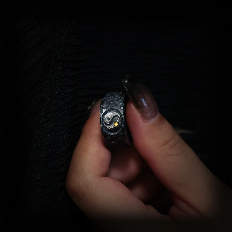 999 Sterling Silver Yin Yang Ring - held between fingers showing side profile of hammered band, Taoist jewelry