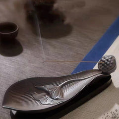 Brown Ceramic Lotus Pod Zen Incense Burner - lit incense smoke on woven fabric, blue accent stripe, peaceful