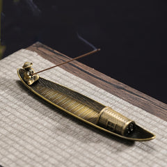 Fisherman Boat Alloy Incense Burner – resting on woven mat with incense smoke, calming ritual