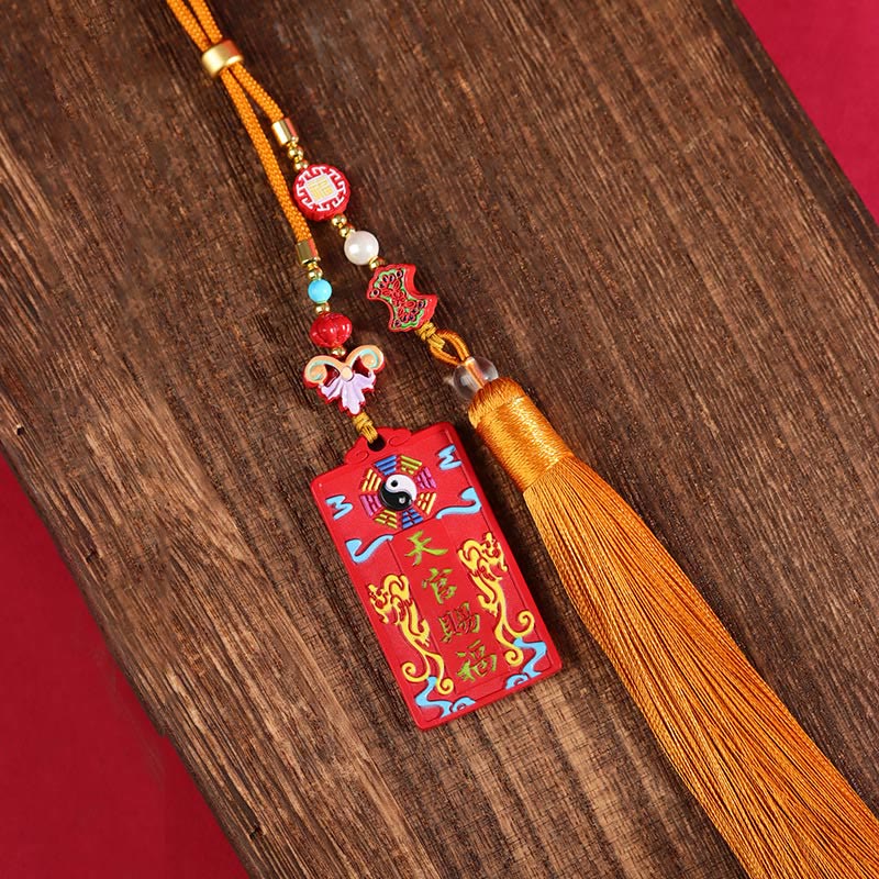 Natural Cinnabar Bagua Yin Yang Fu Hanging - flat lay on dark wood showing full tassel length and beadwork, cinnabar decor