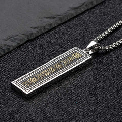 Nine-Word Mantra Bagua Yin Yang Titanium Steel Pendant - Angled pendant on dark stone, two-tone spiritual men jewelry