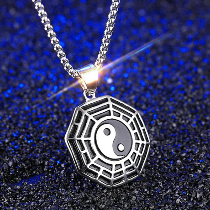 Titanium Steel Bagua Yin Yang Necklace - Silver Bagua pendant with navy blue textured background, three-quarter view