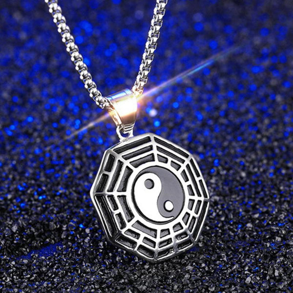 Titanium Steel Bagua Yin Yang Necklace - Silver Bagua pendant with navy blue textured background, three-quarter view