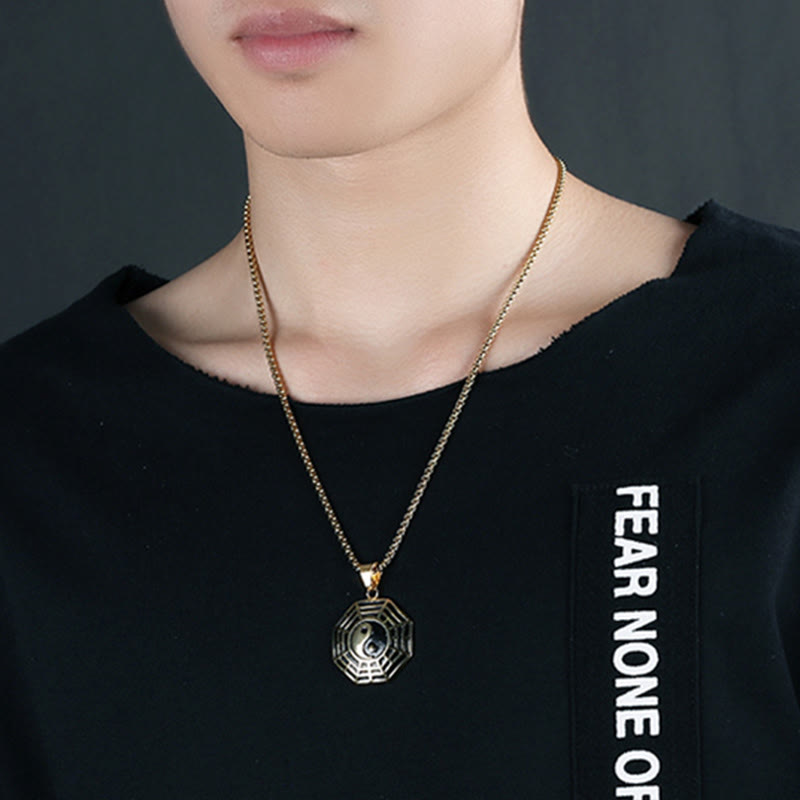 Titanium Steel Bagua Yin Yang Necklace - Gold Bagua pendant worn by male model on black shirt, statement necklace