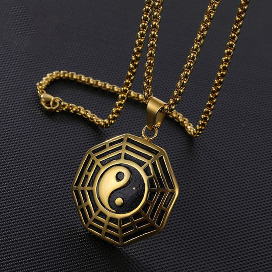 Titanium Steel Bagua Yin Yang Necklace - Gold Bagua octagon pendant on carbon fiber, close-up view