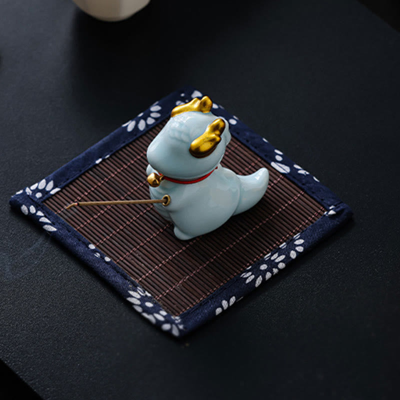 Ceramic Dragon Bell Incense Burner – low side view holding incense with smoke, bamboo mat base, Ritual