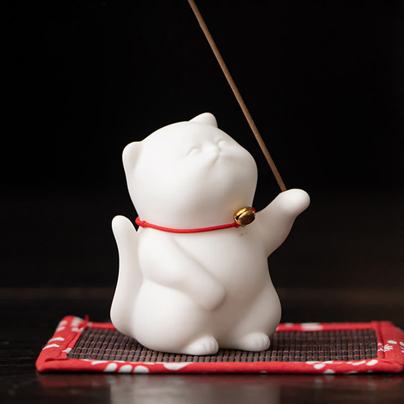 Cat Bell Ceramic Incense Burner – White cat on red polka-dot mat, incense inserted in raised paw, ceramic holder