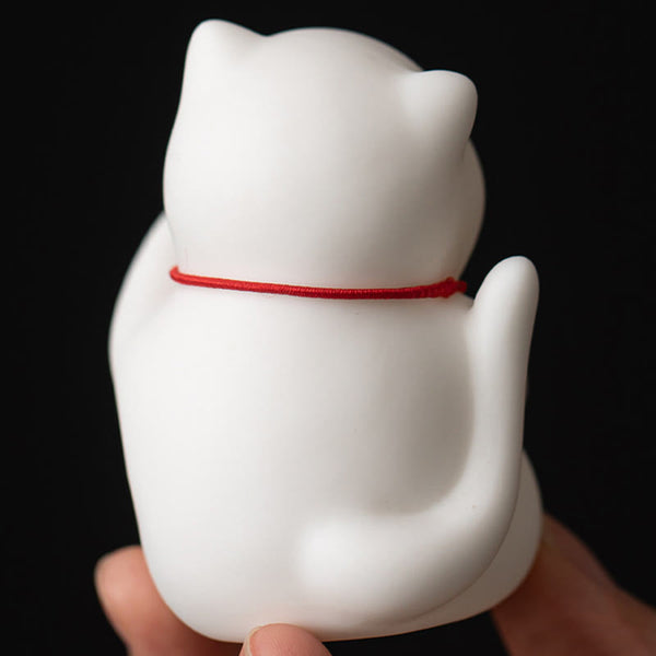 Cat Bell Ceramic Incense Burner – Back view of white cat in hand, red cord visible, compact ceramic figurine