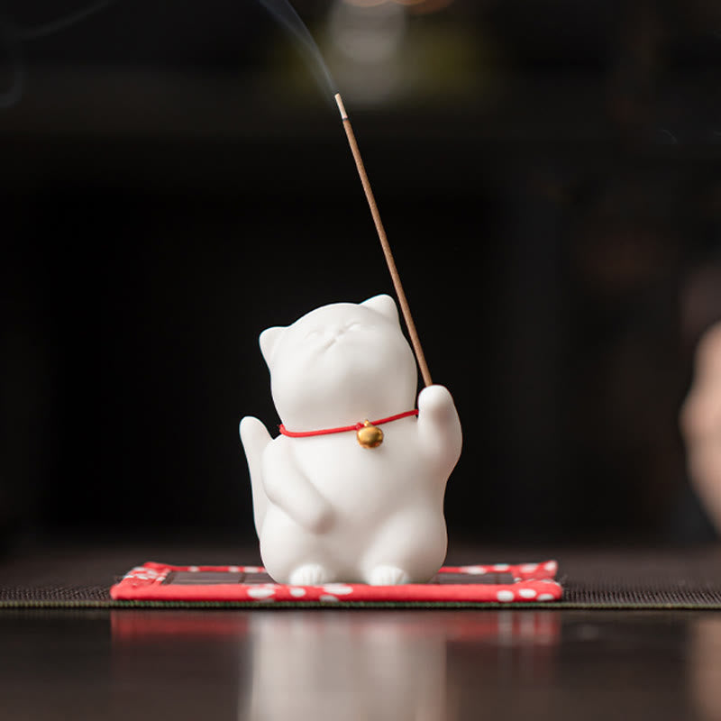 Cat Bell Ceramic Incense Burner – White cat with red bell collar holding lit incense, smoke rising, ceramic incense burner