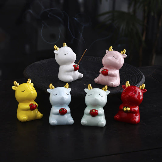 Deer Ceramic Incense Burner – Six color variants with gold antlers on dark surface, white one holding lit incense, ceramic burner