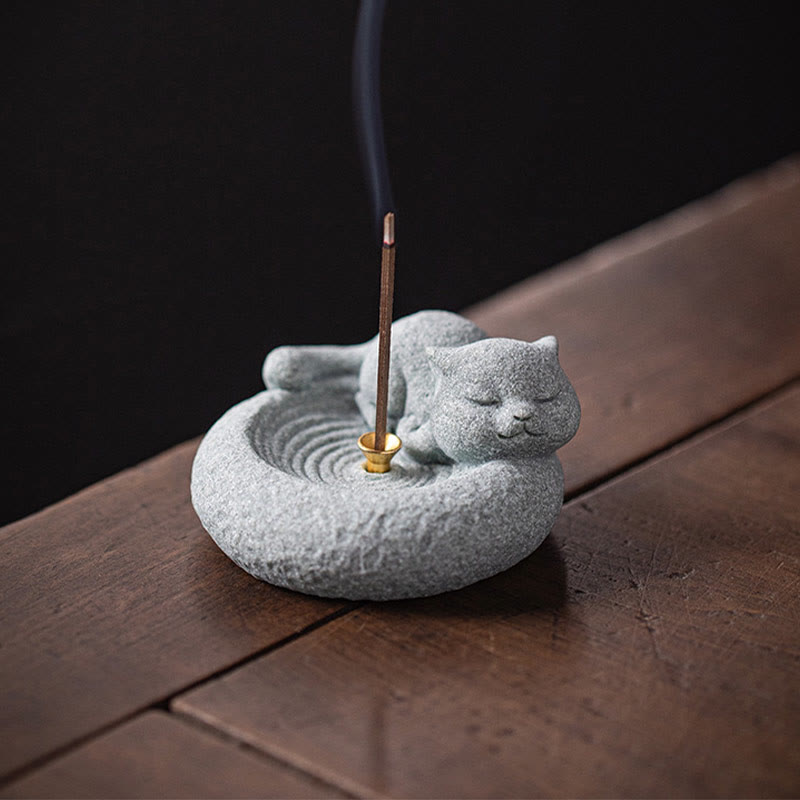 Lazy Cat Sandstone Incense Burner – cat on weathered wood with black background, incense stick lit, artisan stone craft