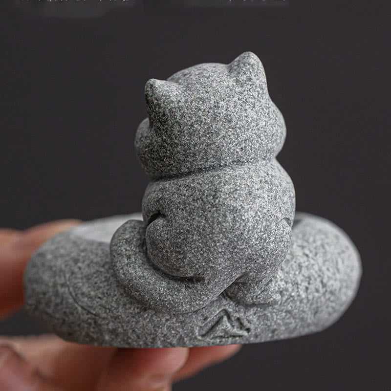 Lazy Cat Sandstone Incense Burner – cat figurine from rear angle held in hand, dark background, textured stone detail