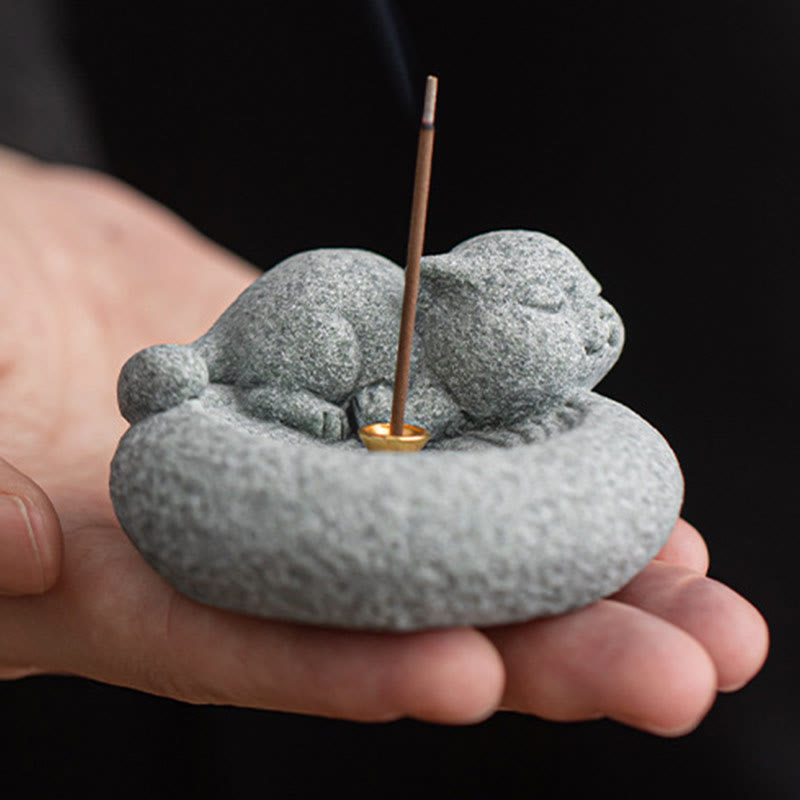 Lazy Cat Sandstone Incense Burner – cat on dark wood table, black backdrop, incense smoke, minimalist zen photography