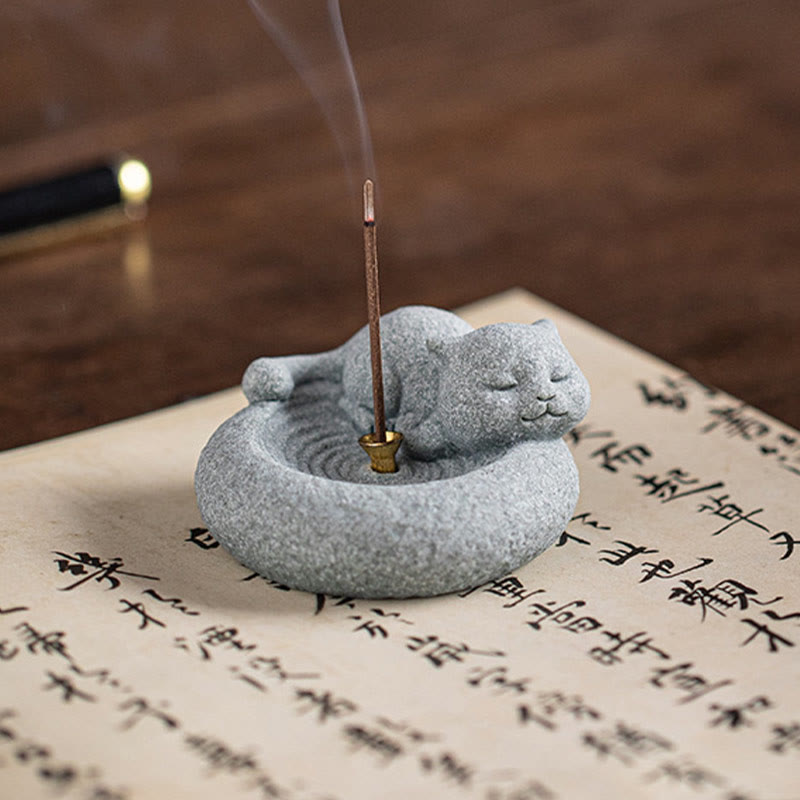 Lazy Cat Sandstone Incense Burner – sleeping cat held in palm with smoke, black background, compact stone zen decor