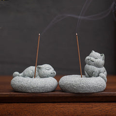 Lazy Cat Sandstone Incense Burner – sleeping and sitting cat pair with incense smoke rising, dark charcoal backdrop, zen h...